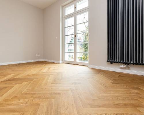 Heller Raum mit Eichen-Fischgrätparkett und modernem Heizkörper