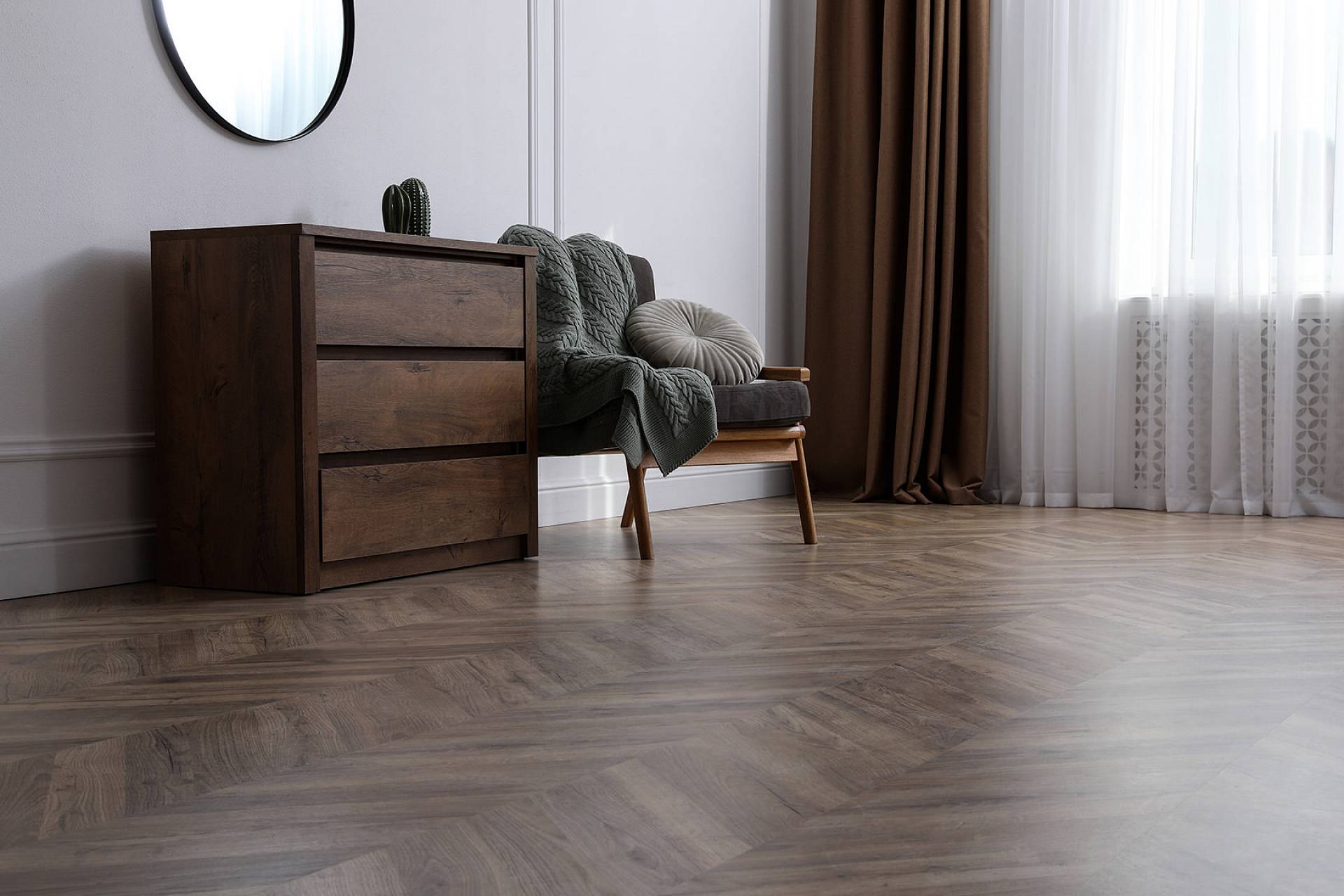 Modern eingerichteter Wohnbereich mit grauem Fischgrätboden in Holzoptik.