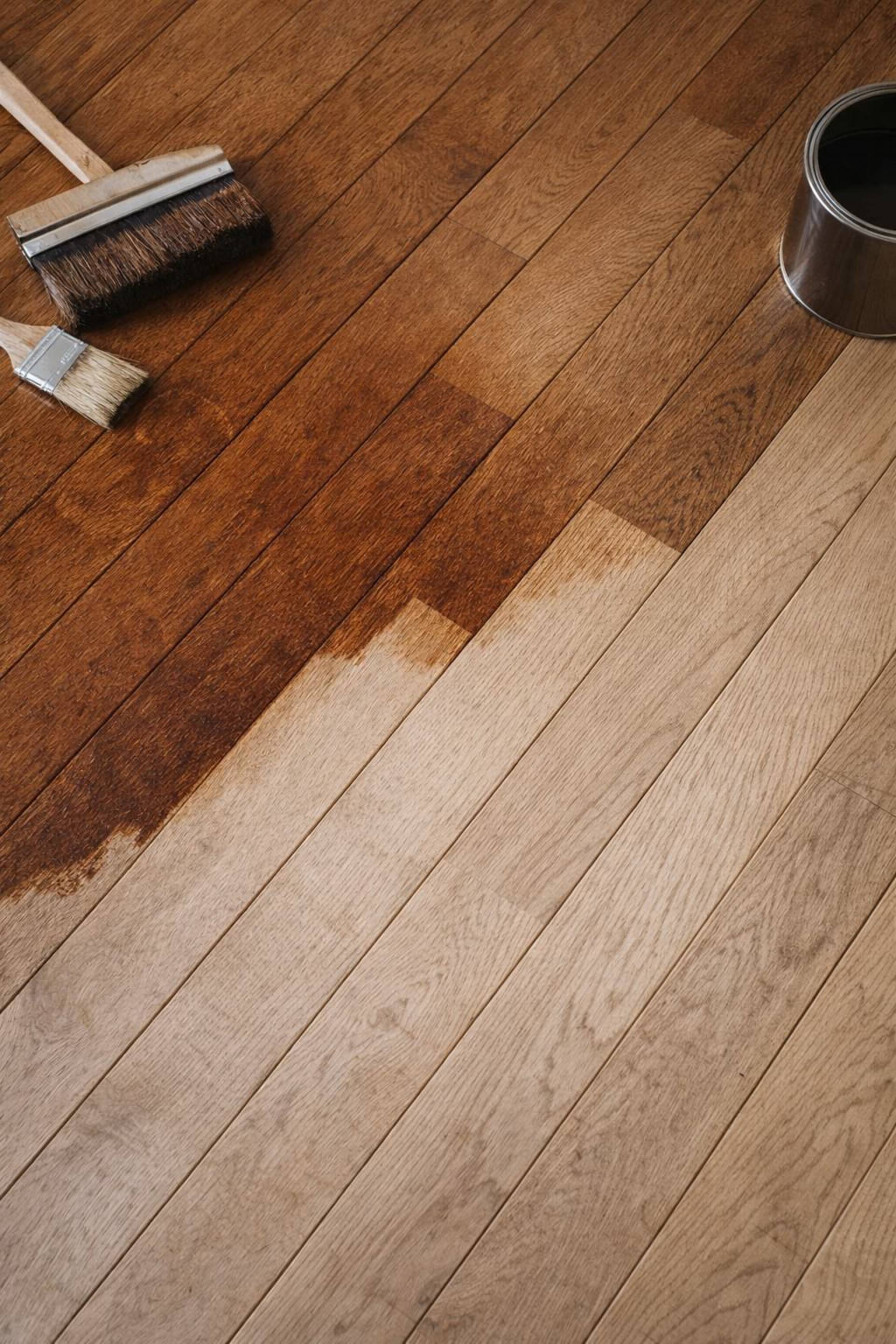 Parkettboden beim Ölen mit Pinsel und sichtbarem Vorher-Nachher-Effekt