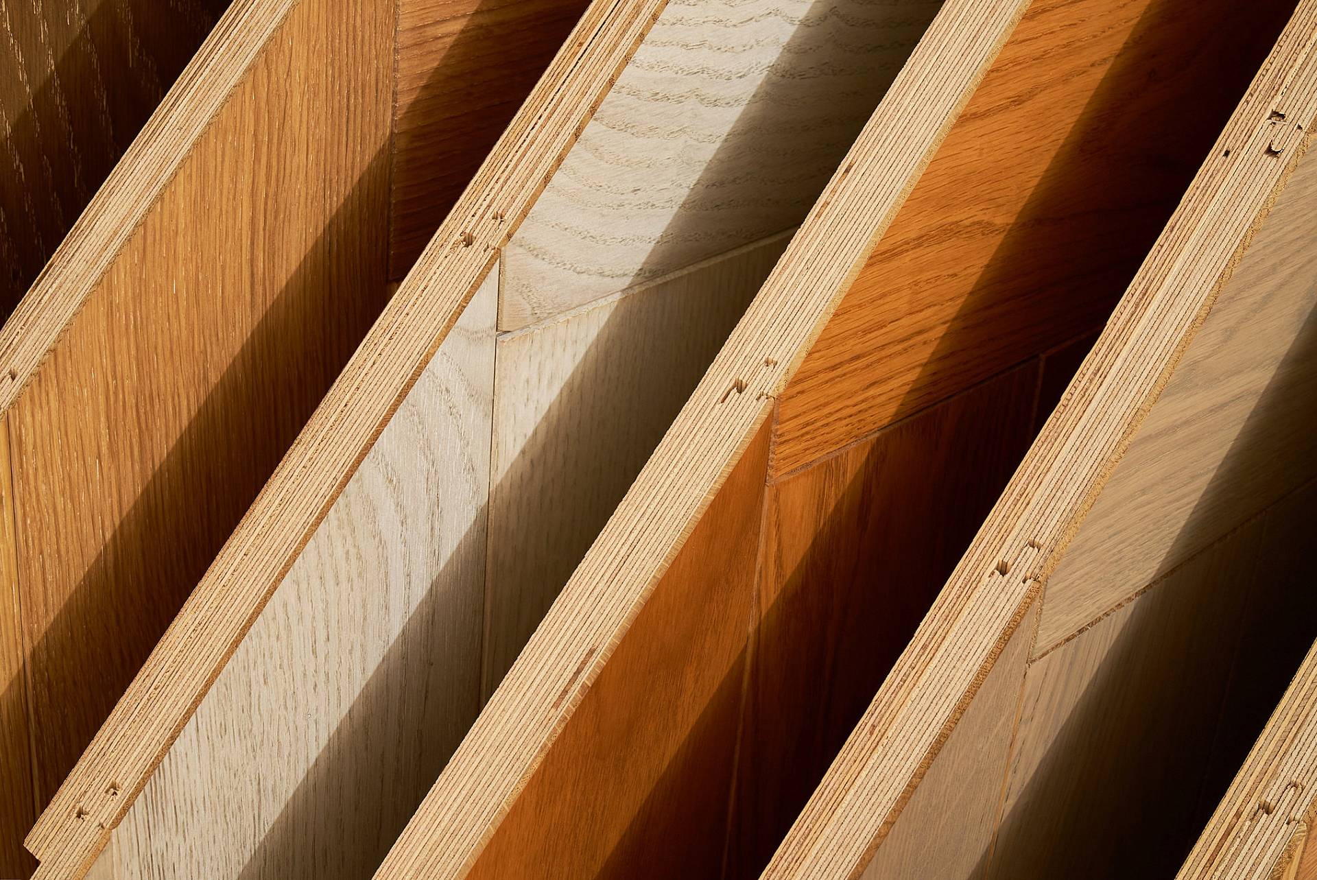 Unterschiedliche Parkettmuster und Holzarten im Sonnenlicht präsentiert
