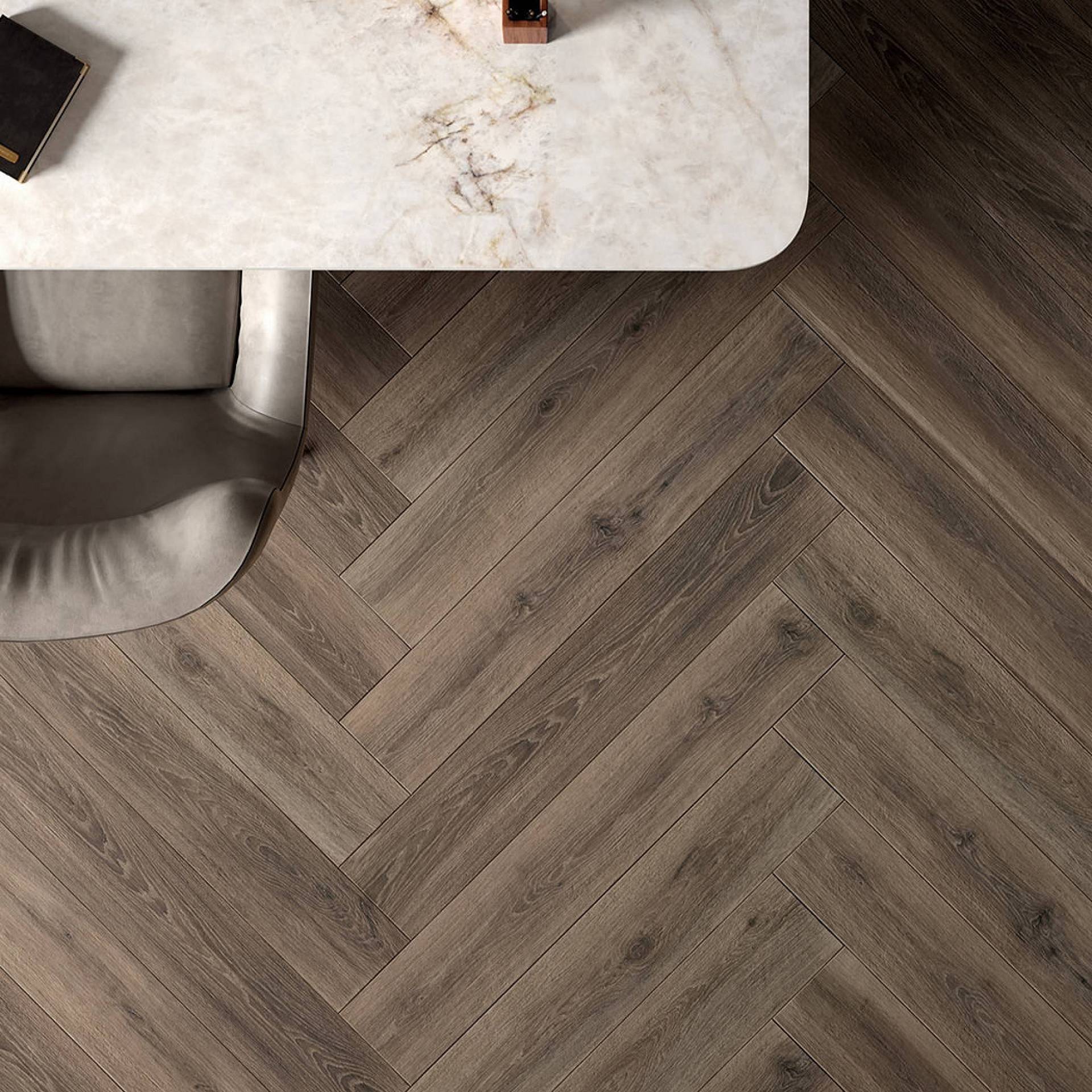 Dunkles Fischgrätparkett unter Esstisch mit moderner Sitzgelegenheit