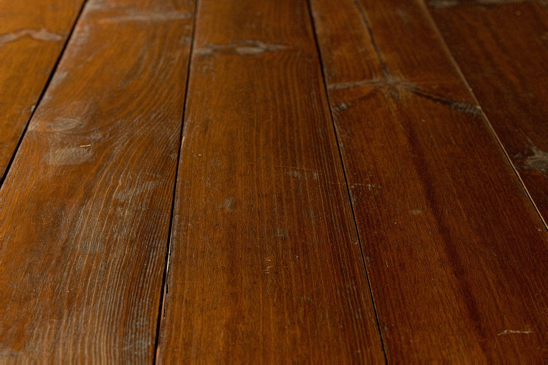 Dunkle Holzdielen mit sichtbaren Gebrauchsspuren und natürlicher Struktur