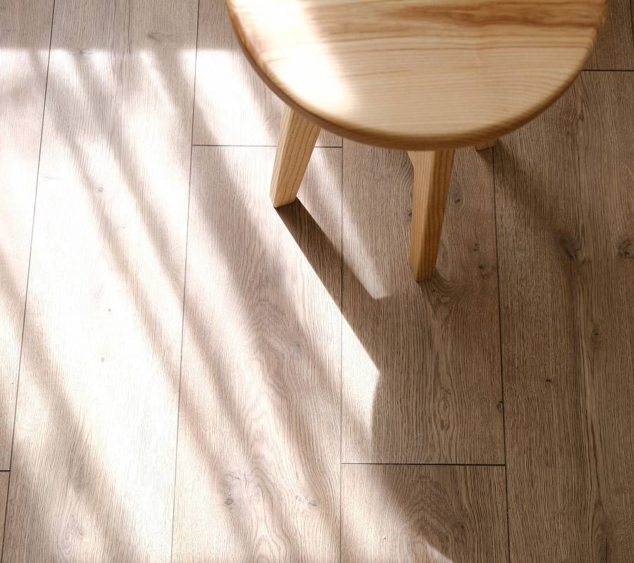 Heller Parkettboden mit Stuhl und weichem Licht-Schatten-Spiel