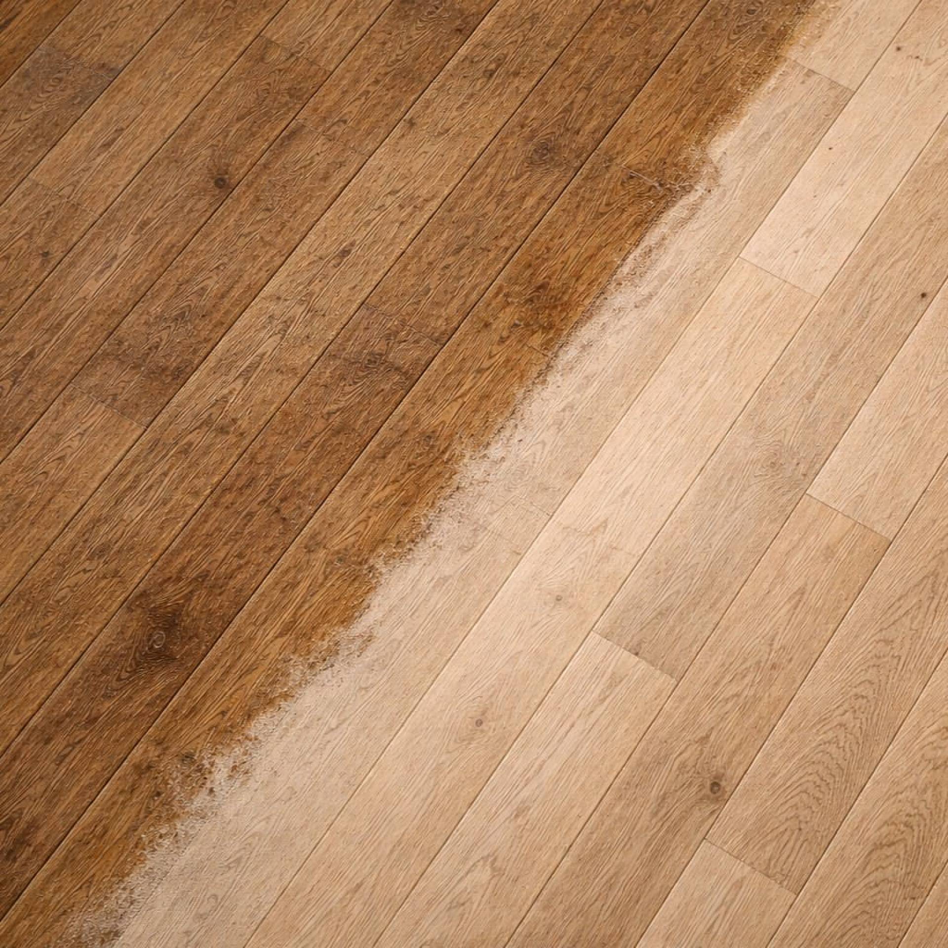 Parkettboden beim Abschleifen mit deutlichem Vorher-Nachher-Unterschied