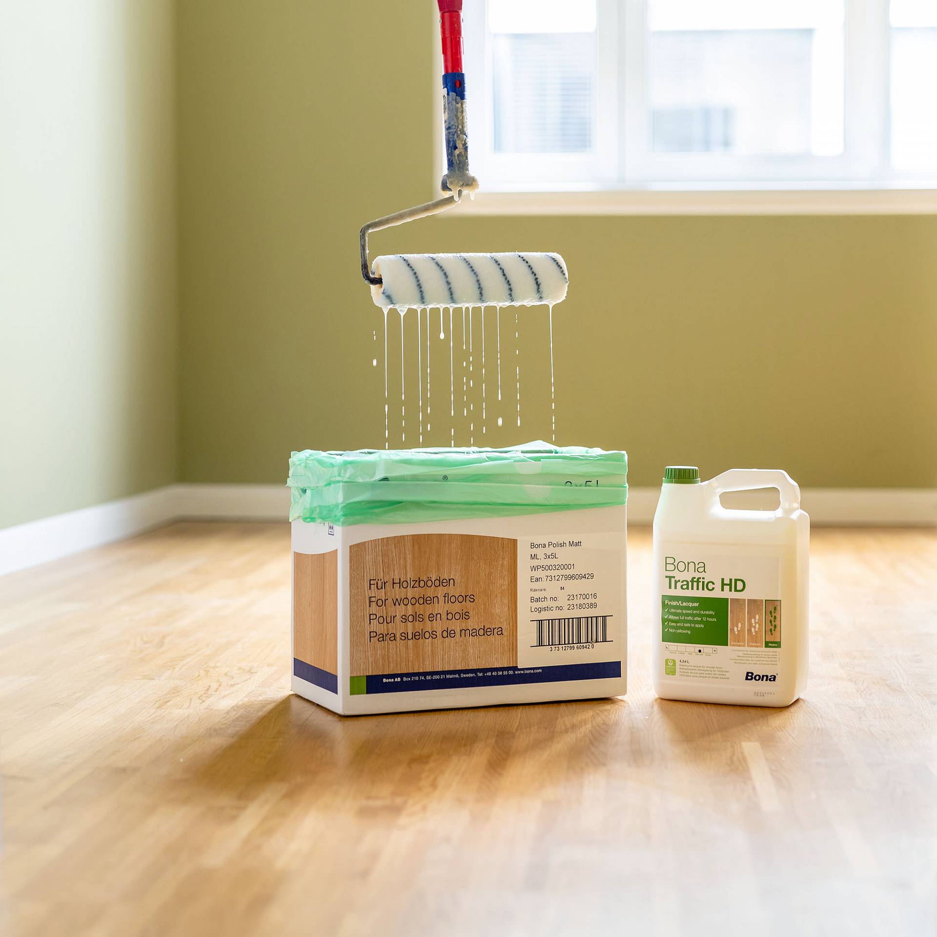 Parkettlack wird mit Rolle auf Holzboden im Raum aufgetragen