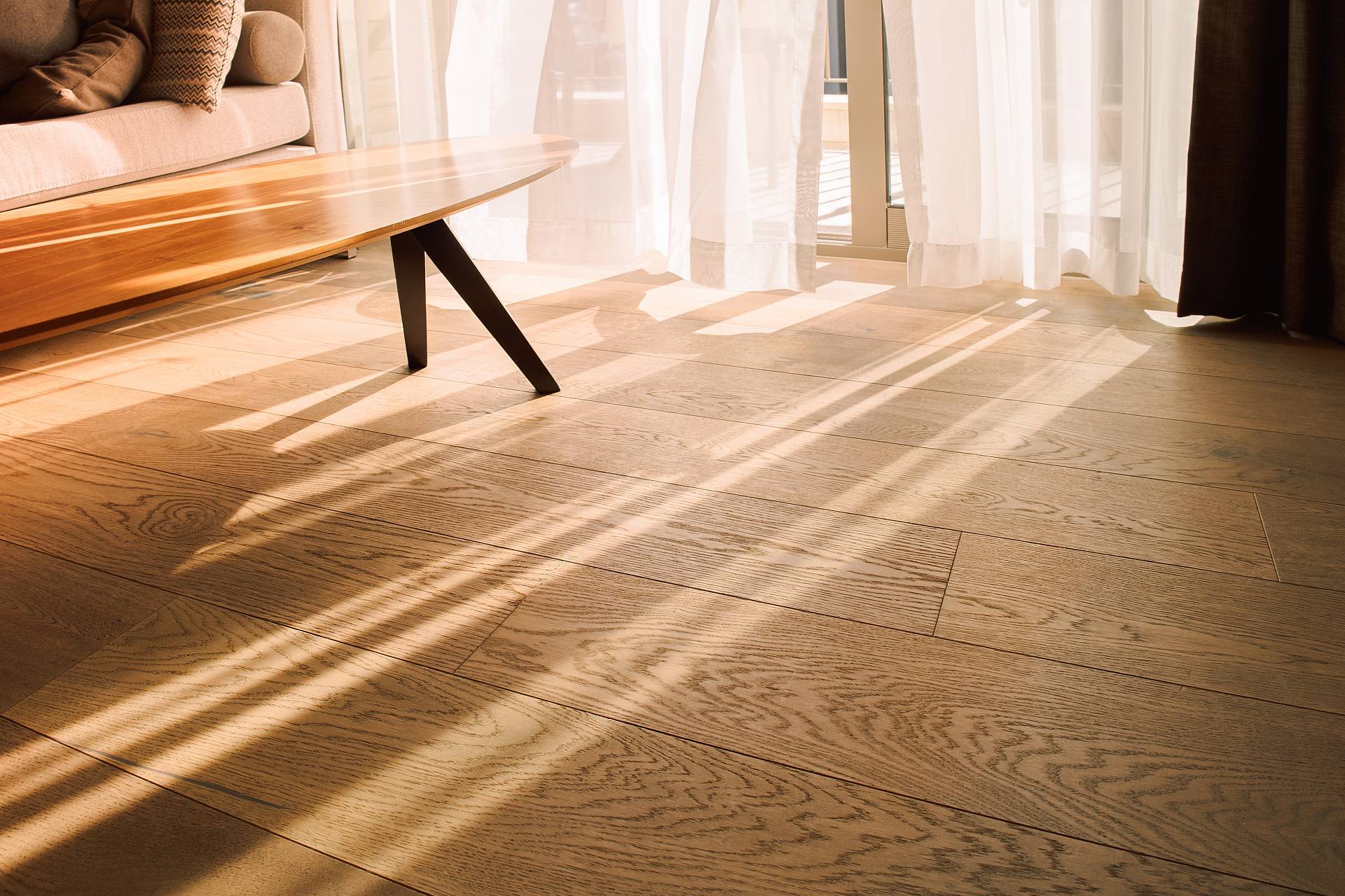 Heller Parkettboden im Wohnzimmer mit weichem Sonnenlicht und Schatten