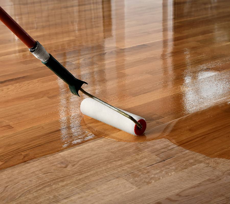 Parkettboden wird mit Rolle geölt, deutlicher Vorher-Nachher-Effekt