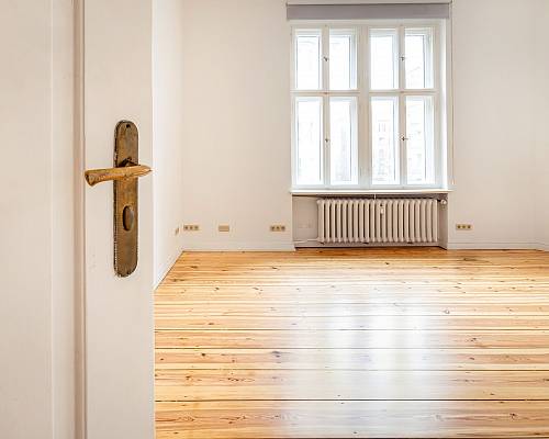 Blick durch offene Tür auf sanierten Dielenboden im Altbau