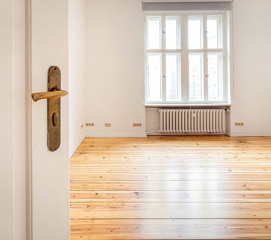 Blick durch offene Tür auf sanierten Dielenboden im Altbau