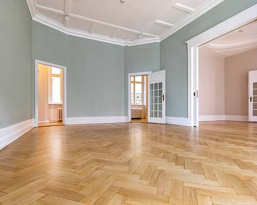 Weitläufiger Wohnraum mit Eichen-Fischgrätparkett und hohen Decken