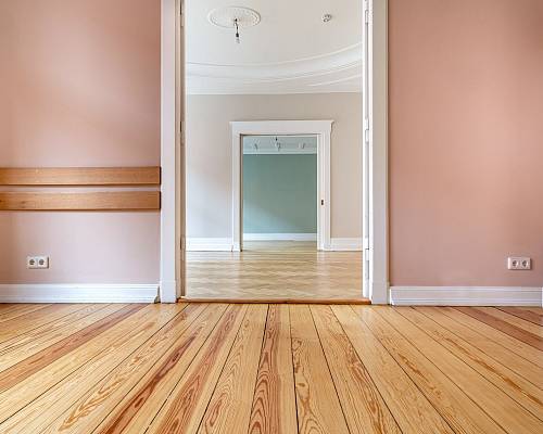 Heller Altbau mit frisch geschliffenem Dielenboden und großen Türrahmen