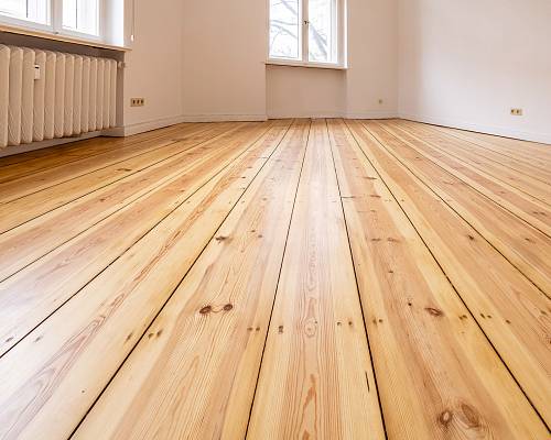 Altbauzimmer mit geschliffenem Dielenboden und klassischem Heizkörper