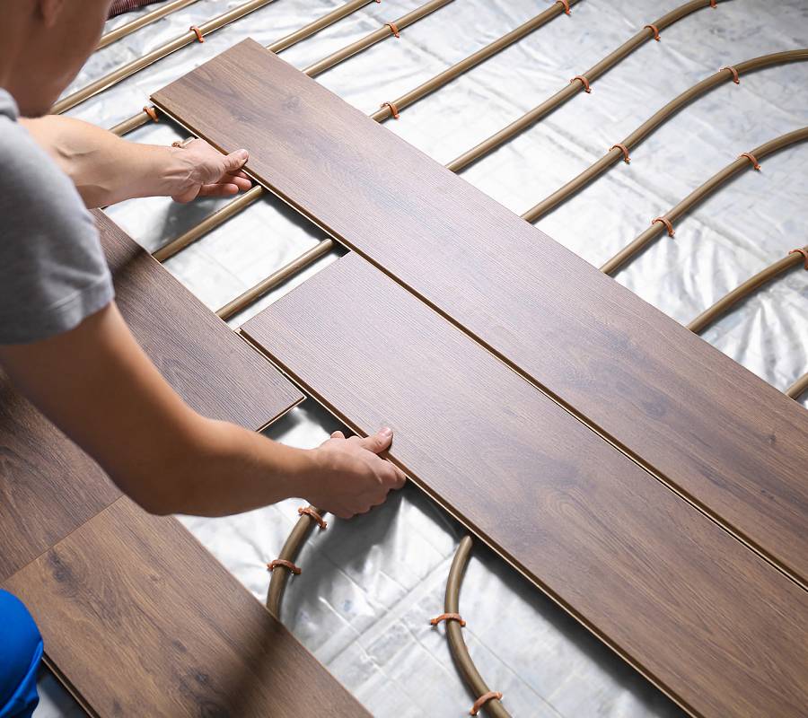 Parkettverlegung auf Fußbodenheizung mit sichtbaren Heizrohren