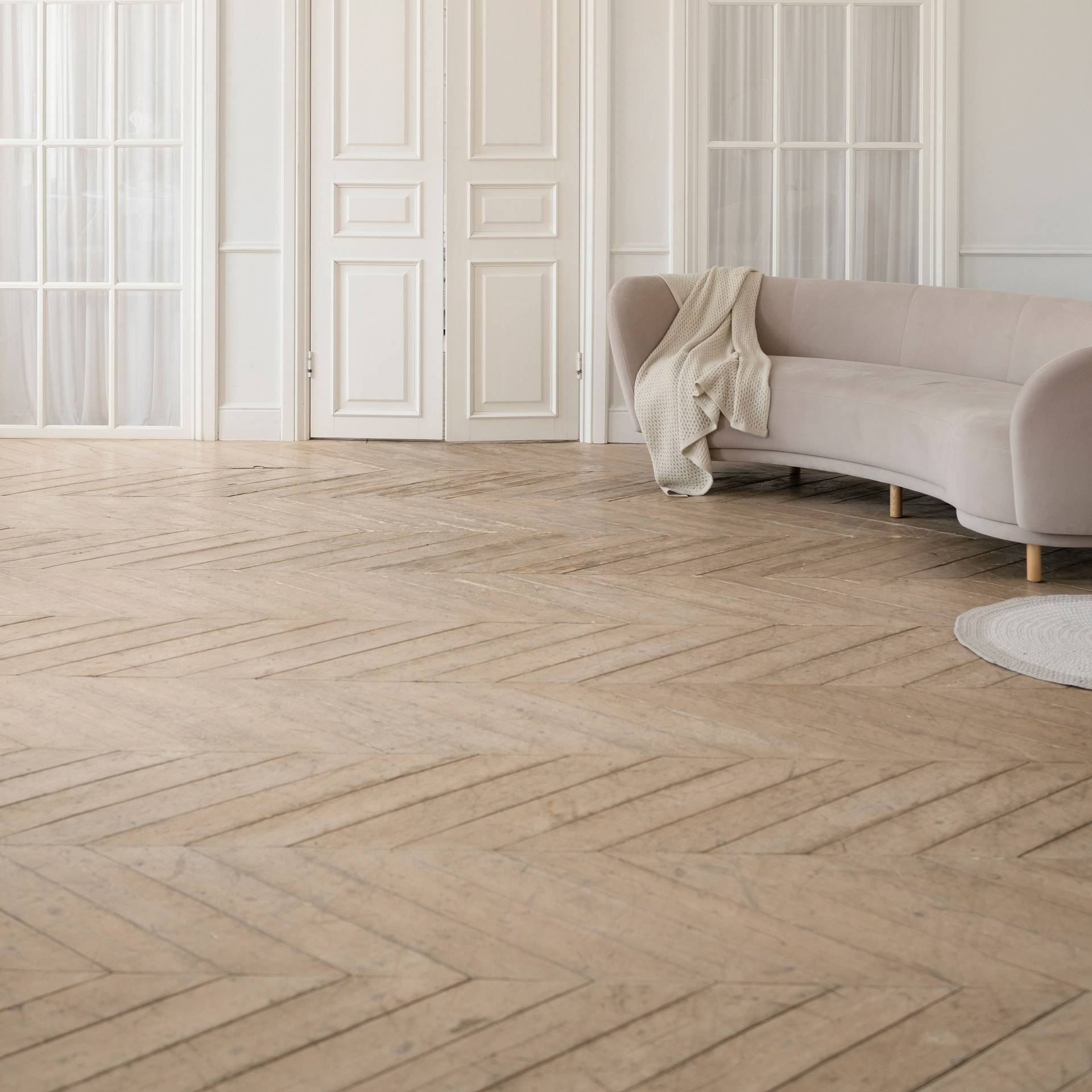 Wohnraum mit hellem Fischgrätparkett und klassischer Raumgestaltung