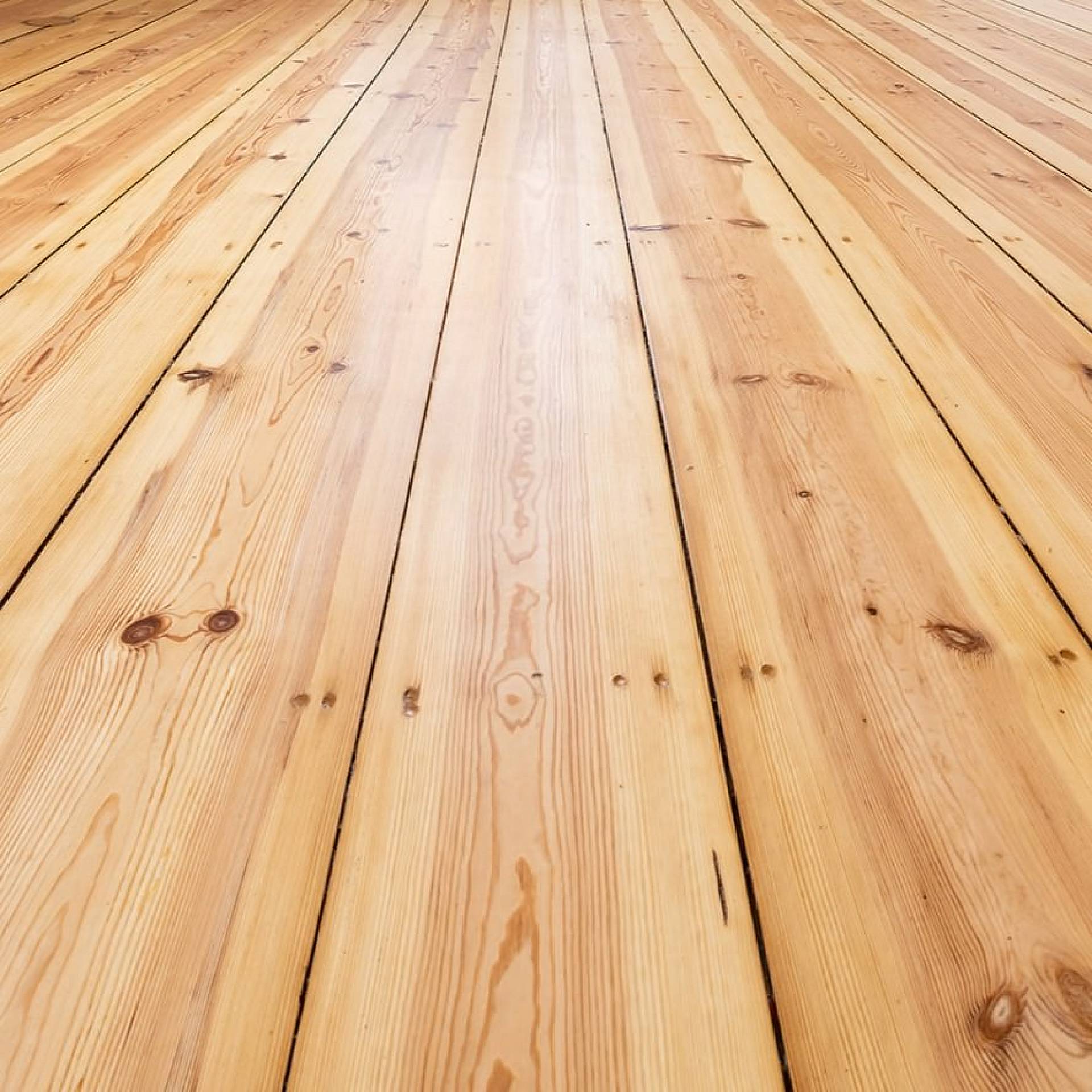 Frisch geschliffene Holzdielen mit sichtbarer Maserung und Astlöchern