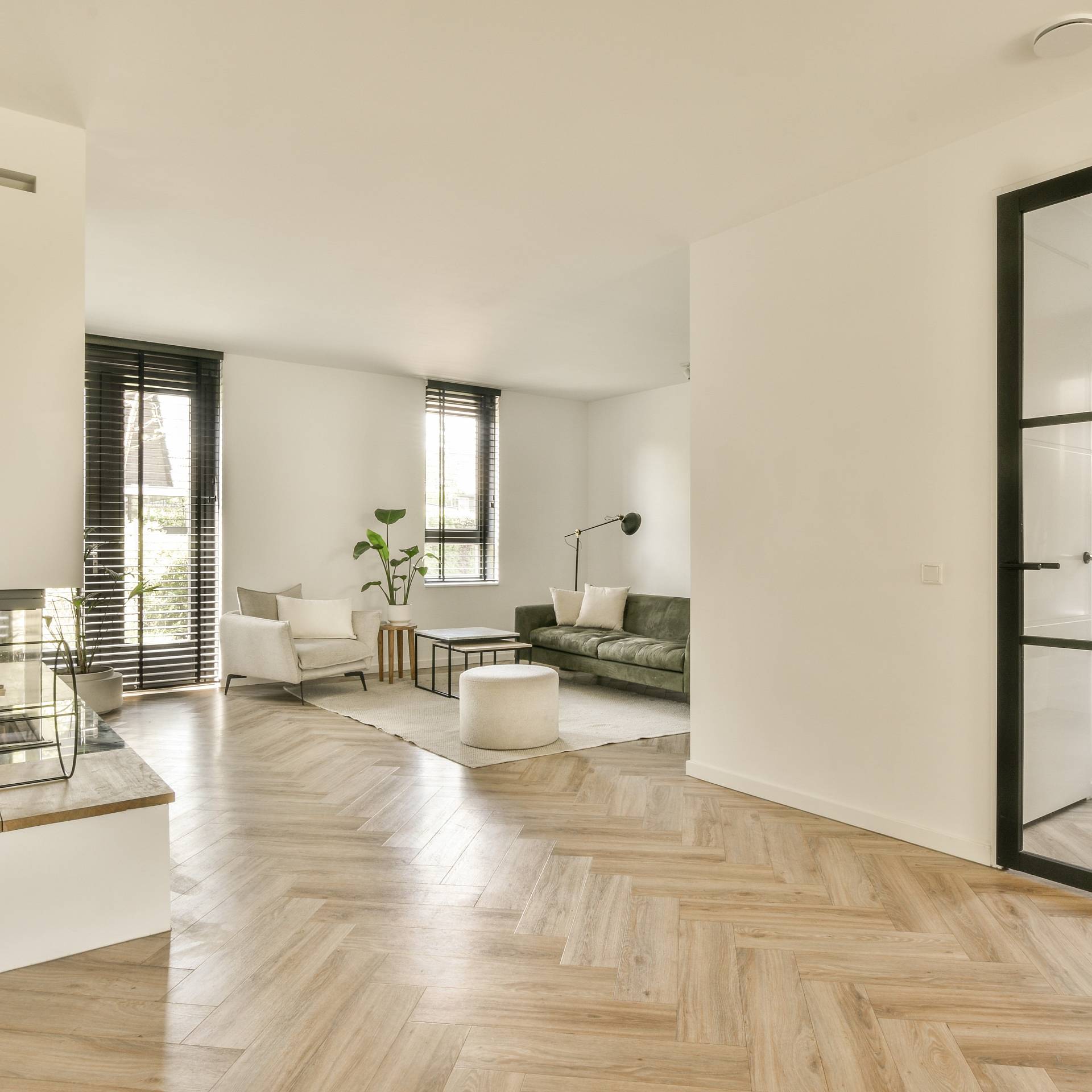 Moderner Wohnraum mit hellem Fischgrätparkett und offener Raumgestaltung