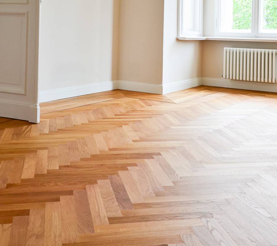 Frisch verlegtes Fischgrätparkett in hellem Wohnraum mit Altbaucharme