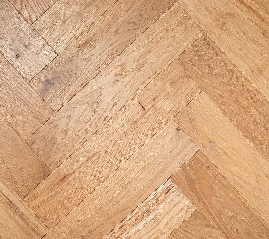 Detailaufnahme von hellem Fischgrätparkett mit natürlicher Holzmaserung