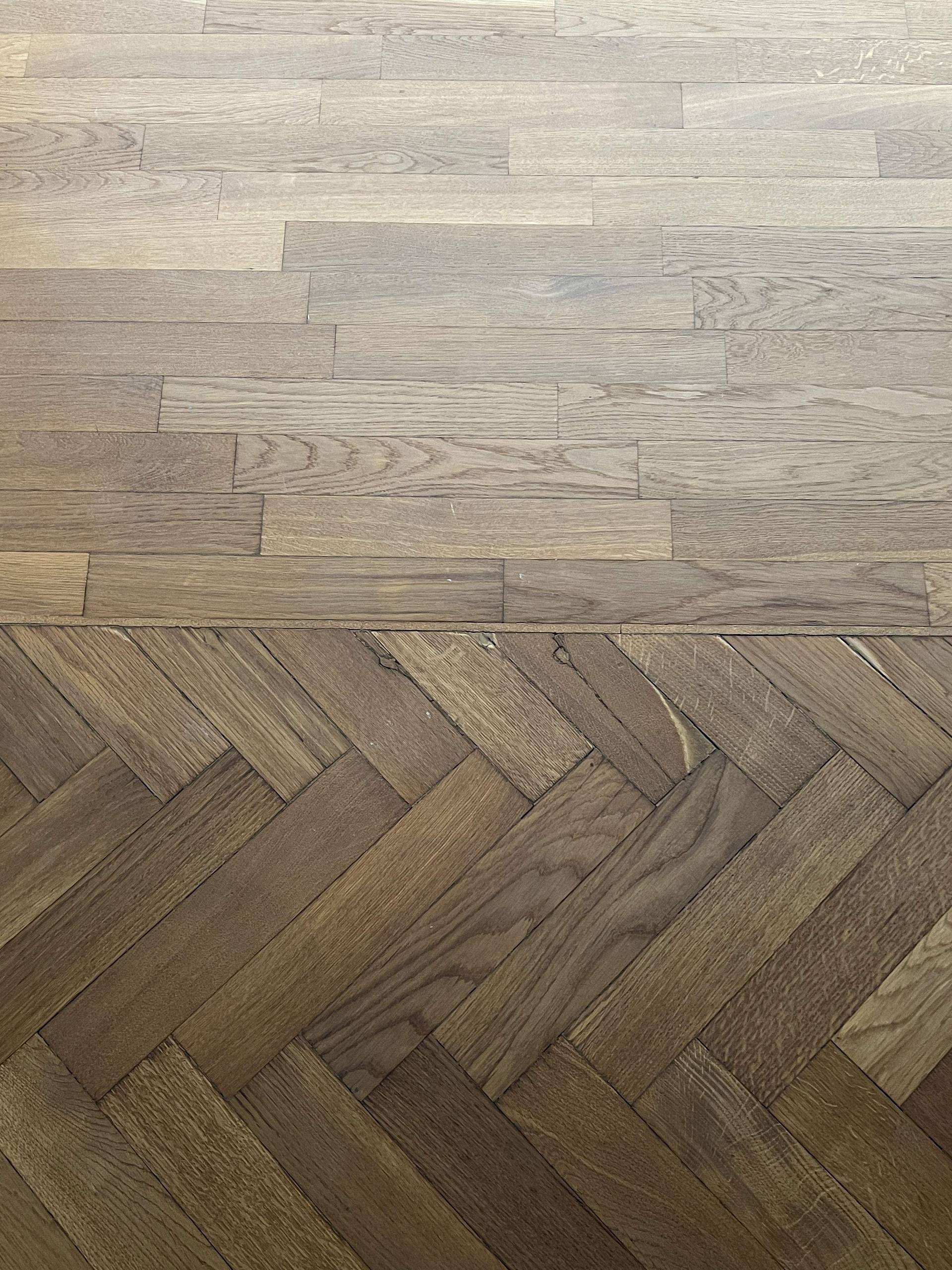 Übergang zwischen hellem Landhausdielenboden und dunklem Fischgrätparkett