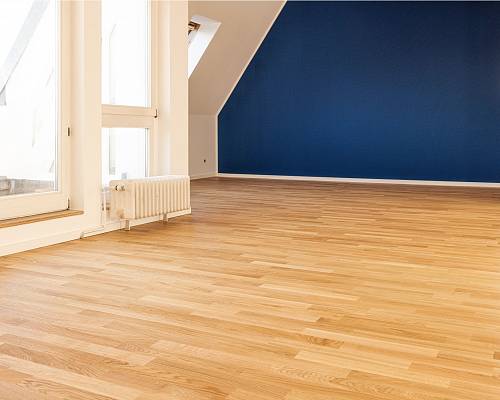 Heller Wohnraum mit Eichenparkett und blauer Akzentwand