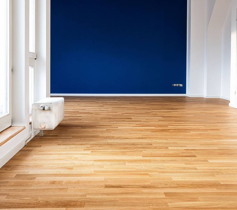 Großzügiges Zimmer mit Parkettboden und kräftiger Wandfarbe