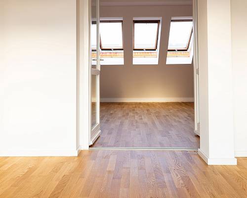 Lichtdurchfluteter Raum mit Parkettboden und großen Dachfenstern