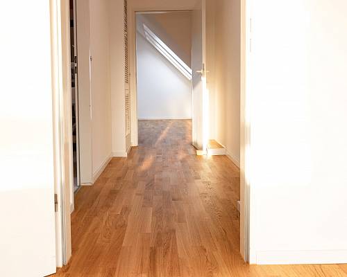 Flur mit warmem Parkettboden und einfallendem Abendlicht