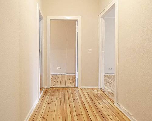 Flur mit aufgearbeiteten Holzdielen und hellen Wänden