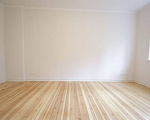 Großzügiges Zimmer mit naturbelassenem Dielenboden und Fensterfront