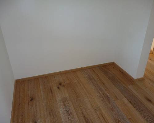 Kompakter Raum mit rustikalem Eichenboden und natürlicher Holzstruktur.