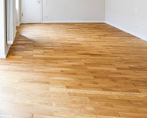 Großzügiger Raum mit neu verlegtem Stabparkett in warmer Eichenoptik.