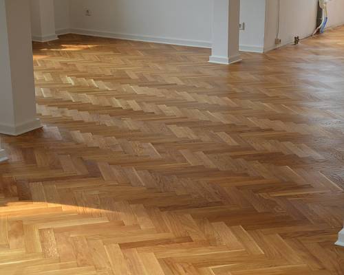 Offener Wohnraum mit hochwertigem, geöltem Fischgrätparkett in Eiche.