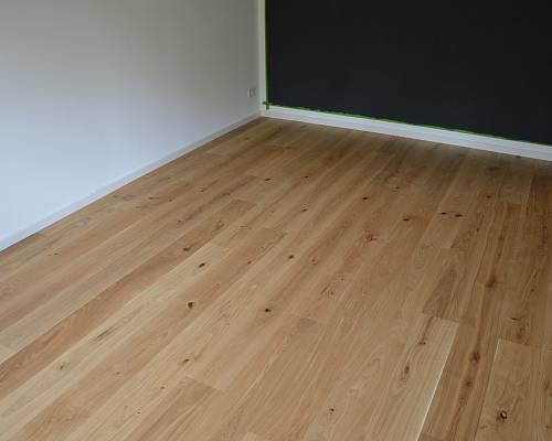 Neu verlegter Dielenboden mit markanter Maserung und ruhiger Raumwirkung.