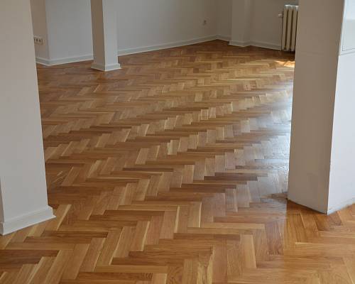 Großzügiger Raum mit frisch geschliffenem und versiegeltem Fischgrätparkett.