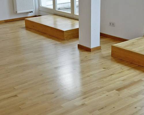 Offener Wohnbereich mit einheitlichem Parkettverlauf und klaren Linien.