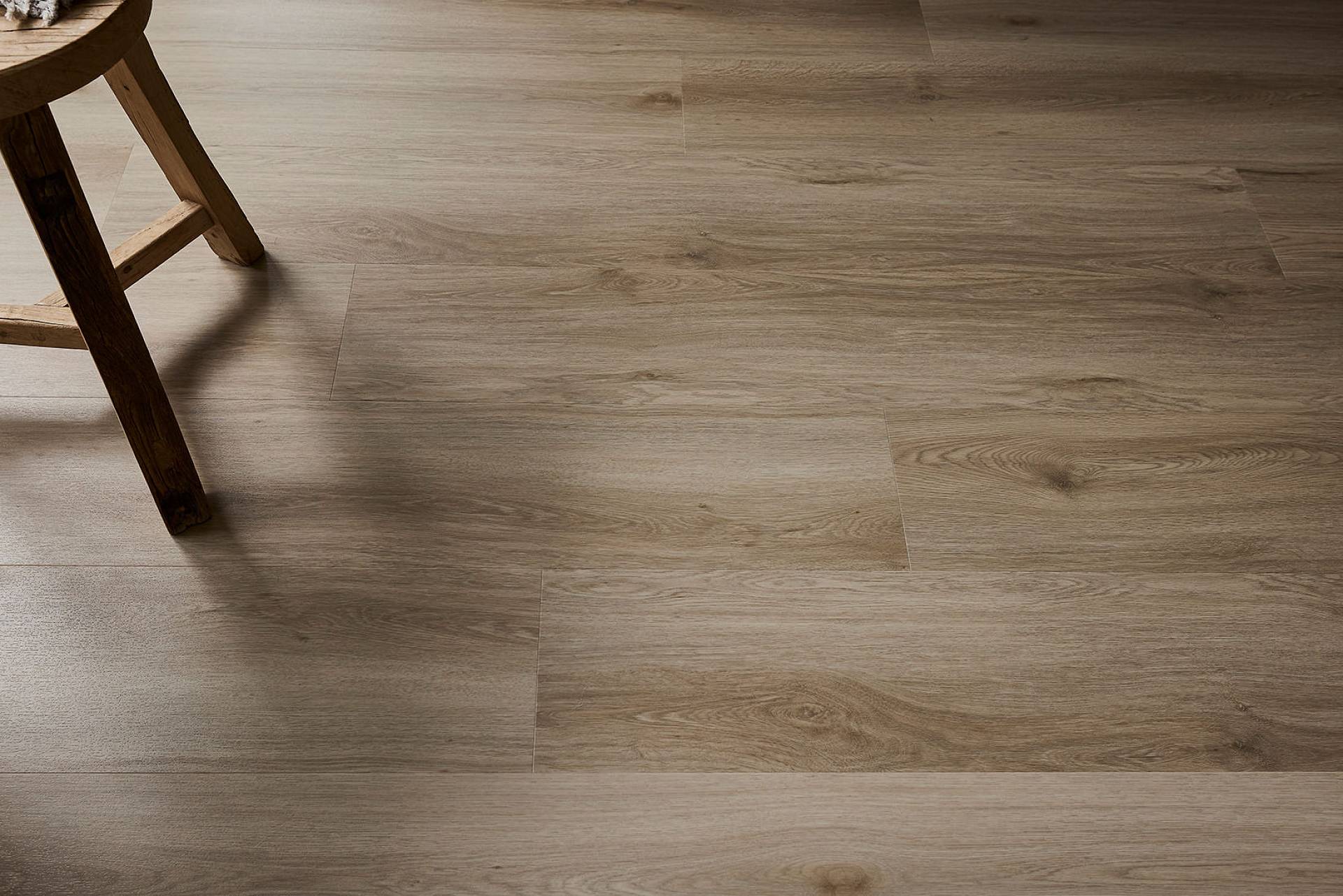 Heller, gleichmäßig gereinigter Holzboden mit natürlicher Maserung und einem Holzstuhl im Hintergrund in ruhiger Wohnatmosphäre.